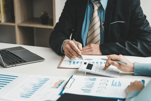 A man in a suit and tie working on papers