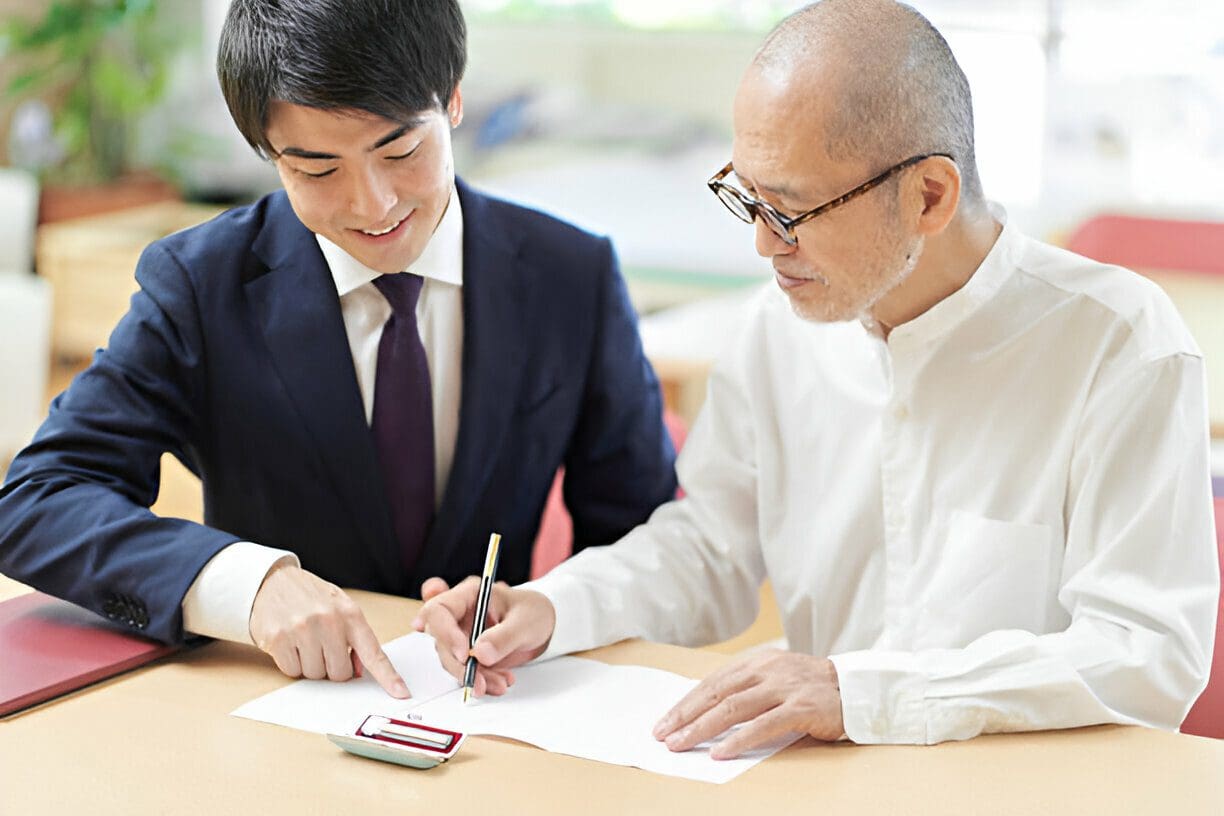 A man and his son are signing papers.