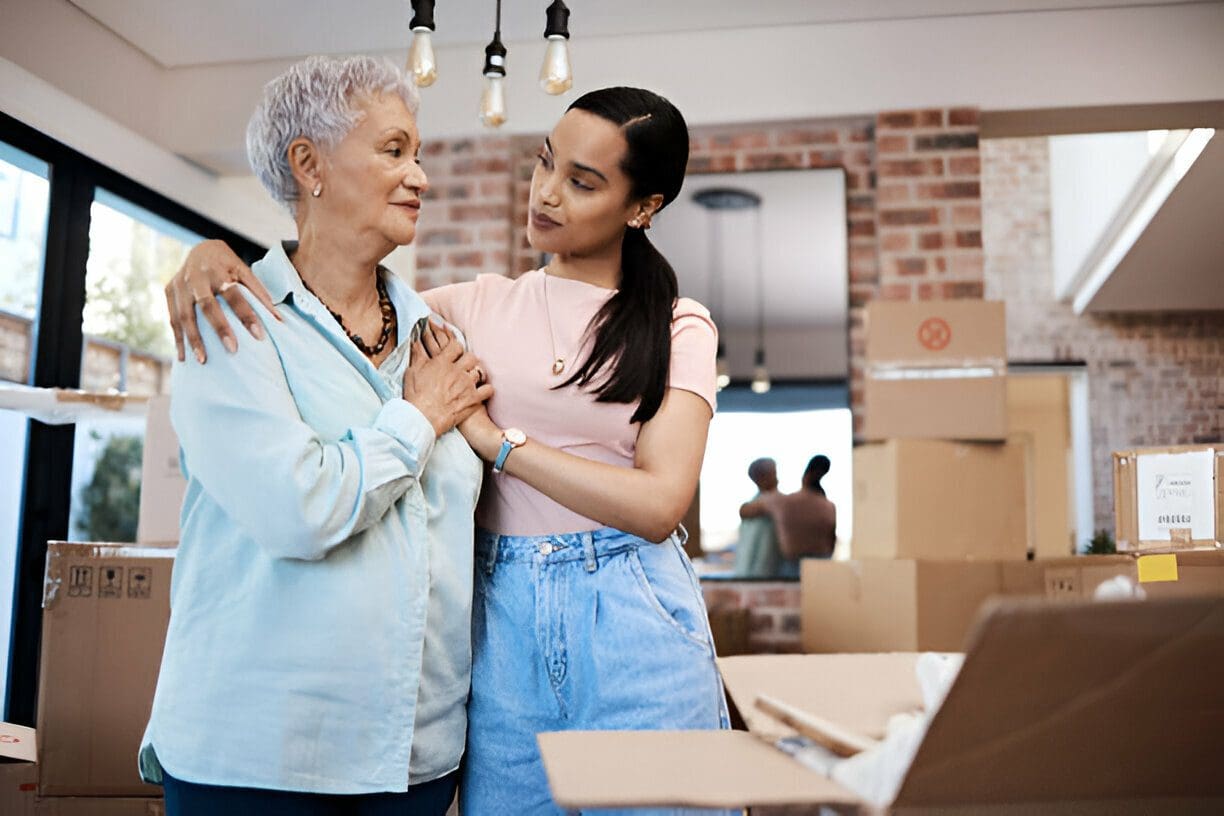 A woman and an older person in front of boxes.