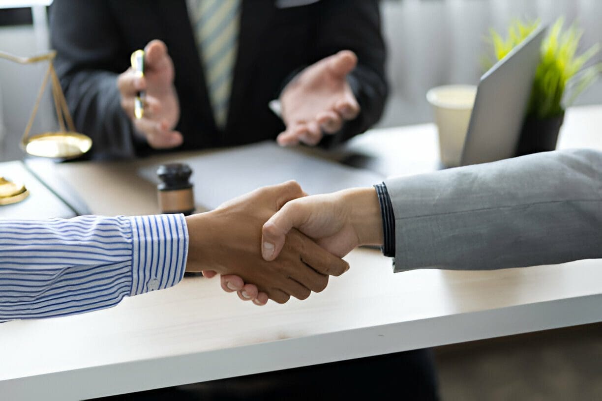 Two people shaking hands over a table