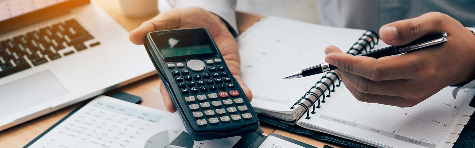 A person holding a calculator in their hand. fiduciary financial planning