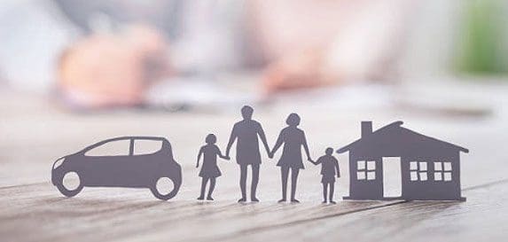 A paper cut out of a family with car and house.