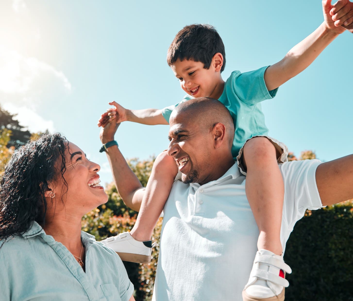 Happy family playing outdoors on sunny day.