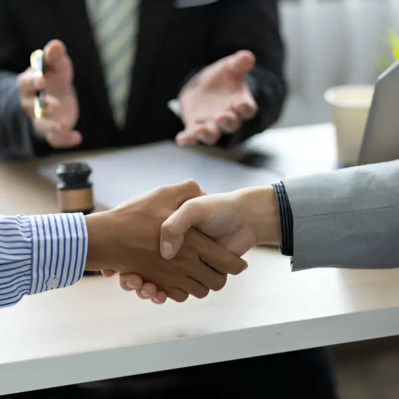 Close up of two people shaking hands in a law office.